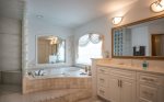 The en-suite bathroom features a massive tub and spacious walk-in shower
